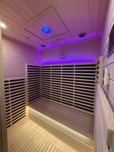 a sauna with purple lights in a room at Regal 40 Srinakarin Apartment in Bangkok