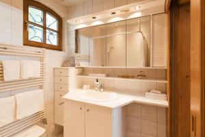 a white bathroom with a sink and a mirror at Villa Marwa - eine Ruheoase im Grünen in Innsbruck