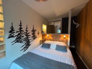 una camera da letto con un letto a scomparsa e alberi di pino di Cosy T2 au Mont Dore Sauna privé et vue montagne proche thermes a Le Mont-Dore