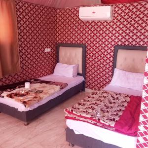 deux lits côte à côte dans une pièce dans l'établissement Faiesal Luxury camp & Tour, à Wadi Rum 11 autres photos