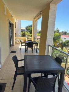 eine Terrasse mit Tisch und Stühlen auf einem Balkon in der Unterkunft Jardins da guia in Albufeira