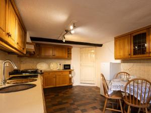 a kitchen with wooden cabinets and a table and a table and chairs at Little Lions Farm in Ringwood
