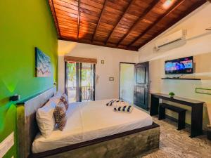 a bedroom with a large bed in a green wall at Sea Shell Villa Hikkaduwa 2 Separate Cabanas Ocean Front Villa in Hikkaduwa