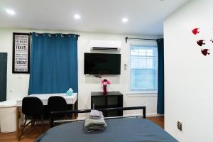 a room with a bed and a desk and a tv at New! Suite near Rittenhouse Square in Philadelphia