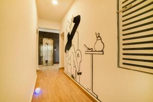a hallway with a wall with a painting of rabbits on it at Townhouse Sarvar Hospitality Near Ascendas Park Square Mall in Bengaluru