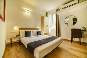 a hotel room with a large bed and a mirror at Townhouse Sarvar Hospitality Near Ascendas Park Square Mall in Bengaluru +40 photos