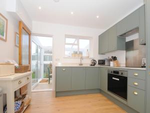 a kitchen with green cabinets and a counter top at Sea Spray in Port Isaac +20 photos