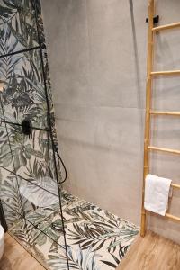 a bathroom with a shower with a wall at The Grandma's house in Artemida