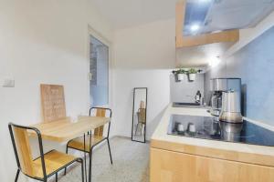 a kitchen with a wooden table and chairs and a counter at Appartement place Stanislas 1er in Nancy