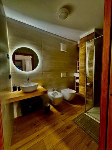 a bathroom with two sinks and two mirrors at B&B Soreghina in Malè