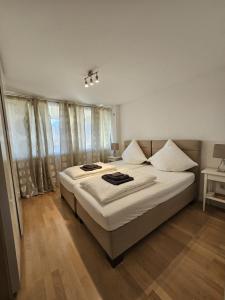 ein Schlafzimmer mit einem Bett mit weißen Laken und Fenstern in der Unterkunft OEZ 3 Zimmer Wohnung in München