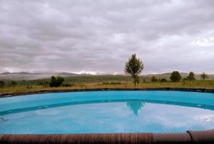 a large swimming pool with a view of the mountains at Wooden veggie house Koliba near Plitvice Lakes in Plaški