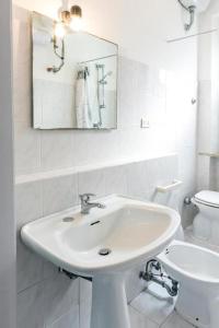 a white bathroom with a sink and a toilet at M080 - Marcelli, residence Mare Verde trilo con giardino in Marcelli +31 photos