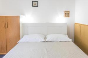a bedroom with a white bed with two pillows at M080 - Marcelli, residence Mare Verde trilo con giardino in Marcelli