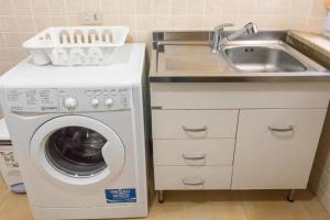 a kitchen with a washing machine and a sink at M080 - Marcelli, residence Mare Verde trilo con giardino in Marcelli