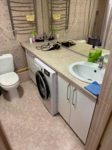 un bagno con lavandino e lavatrice di Elite Apartments a Bishkek