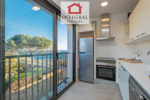 een keuken met een balkon met uitzicht op de oceaan bij L'Àtic de Palamós in Palamós