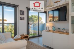 een woonkamer met een bank en een tv bij L'Àtic de Palamós in Palamós