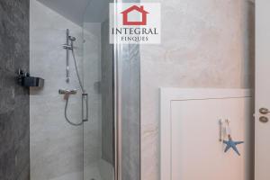 een douche met een glazen deur in een badkamer bij L'Àtic de Palamós in Palamós +17 foto's