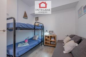 een slaapkamer met twee stapelbedden en een bank bij L'Àtic de Palamós in Palamós