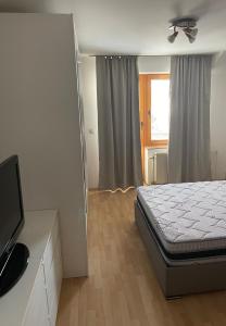 a bedroom with a bed and a flat screen tv at BT Lux apartment 2 in Skopje