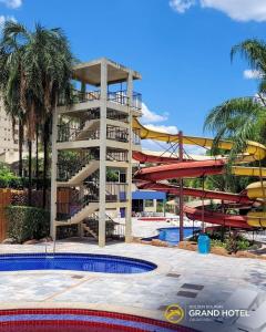 a building with a water slide next to a pool at Golden Dolphin Grand Hotel piscinas 24 hs MP in Caldas Novas