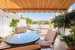 a patio with a table and chairs on a balcony at La casa de Montse Vivienda Vacacional Playa de la Tejita in El Médano