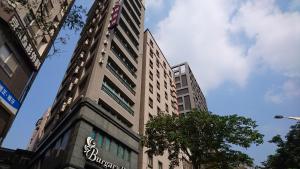 een hoog gebouw met een bord aan de zijkant bij Burgary Hotel in Taipei