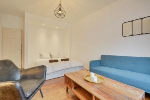 a living room with a blue couch and a table at Appartement Place Stanislas 2 in Nancy