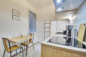 a kitchen with a wooden table and a counter top at Appartement Place Stanislas 2 in Nancy +19 photos