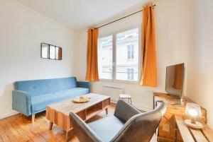 a living room with a blue couch and a table at Appartement Place Stanislas 2 in Nancy