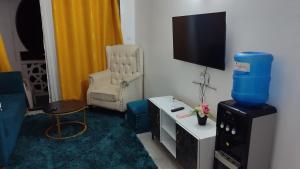 a living room with a chair and a television at Marty's Apartment in Mombasa