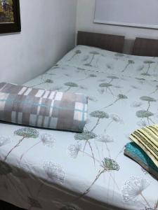 ein Bett mit einer Decke, die mit Löwenzahn bedeckt war in der Unterkunft Pousada da Maria in São Gabriel