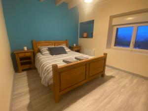 a bedroom with a wooden bed and a window at Gite familial en Valromey in Brénaz