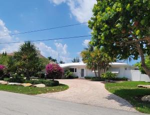 a white house with trees and a driveway at The views rental house in Pompano Beach