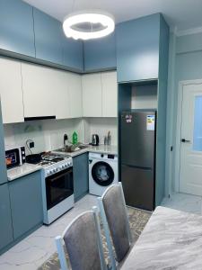 Una cocina con gabinetes azules, una estufa y un lavavajillas. en Luxury Apartments, en Bishkek