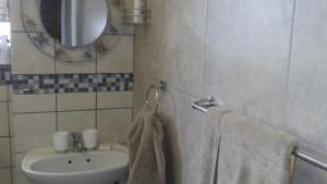 une salle de bain avec un lavabo, un miroir et des serviettes dans l'établissement Ocean Elephant Beach Apartment, à Strand 23 autres photos