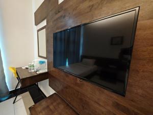 a large flat screen tv hanging on a wall at Citrine Hotel in Seri Iskandar