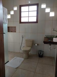 un bagno con un water, un lavandino e una finestra di Cataguás Brasil Pousada a Carrancas
