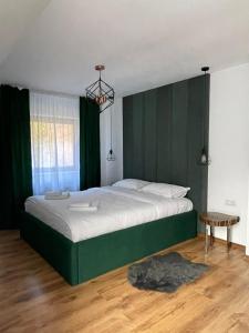Un dormitorio con una cama grande con cabecero verde. en Eden Chalet, Cabana Eden, en Firiza-de-Jos 15 fotos más
