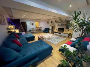ティミショアラにあるGrazia Apartmentの青いソファ付きの広いリビングルーム、
