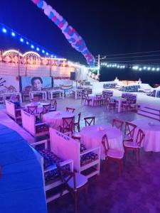 una fiesta con mesas rosas, sillas y luces en Kulaih nubian guest house, en Asuán 142 fotos más