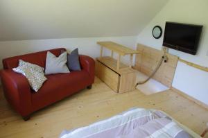 a living room with a red couch and a table at Schwalbenhaus-Netzow in Templin