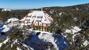 widok z góry na dom pokryty śniegiem w obiekcie La Dora Mountain Resort w mieście Divčibare