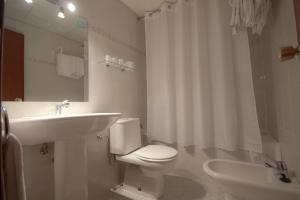 a bathroom with a white toilet and a sink at Hotel Fornos in Calatayud