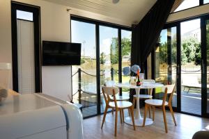 a living room with a table and chairs and a television at Domy Na Wodzie La Mare Houseboats Bydgoszcz in Bydgoszcz
