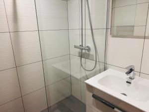 une salle de bain avec douche et lavabo dans l'établissement Appartement cozy 3 pièces avec terrasse et parking au centre, près des pistes - FR-1-464-235, à Pralognan-la-Vanoise