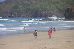a group of people walking on the beach at Villa Serenity 6 bedroom - 1 minute to the beach in Santa Cruz