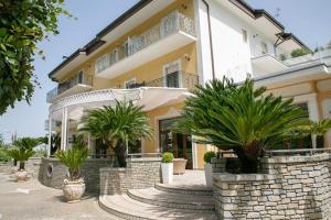 a large building with palm trees in front of it at Villa Donna Carmela in Pimonte
