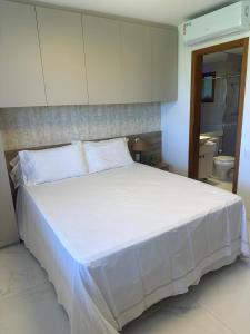 Una cama blanca grande en una habitación con cocina. en Luxury house at Praia do Forte, en Mata de Sao Joao 23 fotos más